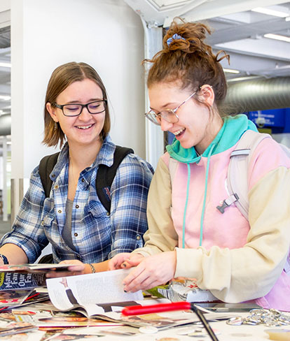 Students smiling while looking at magazines