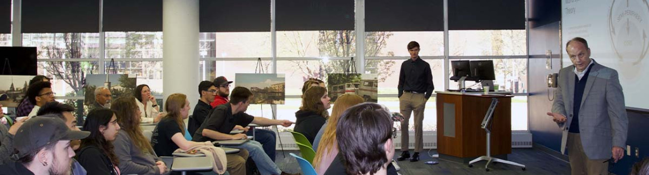 Auraria Creates member giving a lecture to a room full of students and faculty