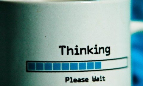 A mug with the inscription "Thinking ... Please Wait".
